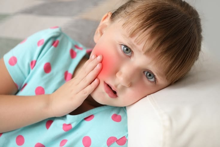 Pediatric dentist examining child with tooth infection